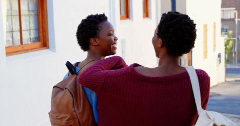 Rear View of African American Twin Sisters Enjoying City Walk