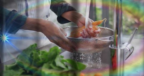 Rinsing raw chicken in colander at kitchen sink washing hands for safe food preparation