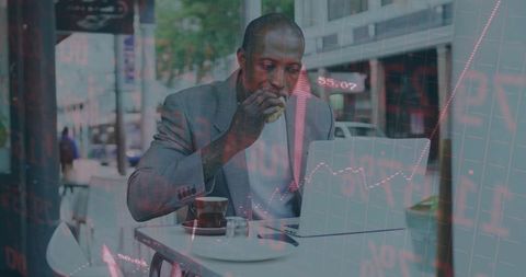 Businessman at Sidewalk Cafe Analyzing Data on Laptop