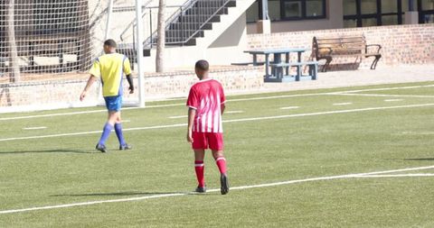 Young soccer player walking on field during practice