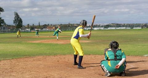Diverse softball players in action on local field