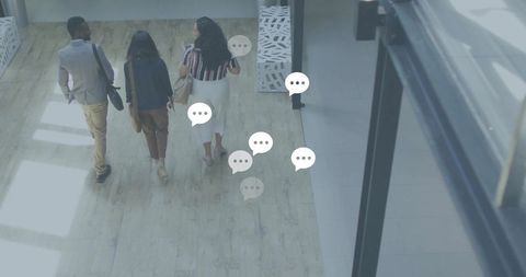 Business professionals walking modern glass lobby carrying bags with chat bubble overlays