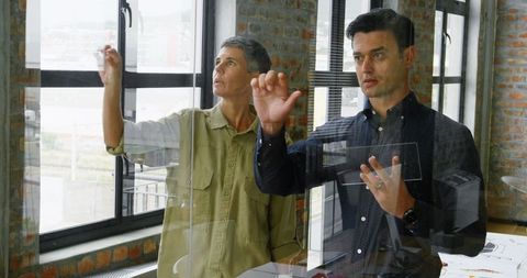 Engineers analyzing data on transparent digital interface