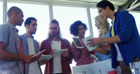 Diverse team in bright meeting space collaborating on technology