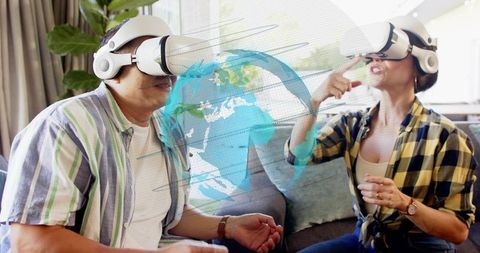 Couple Exploring Virtual Globe Wearing VR Headsets on Couch with Interactive Hologram
