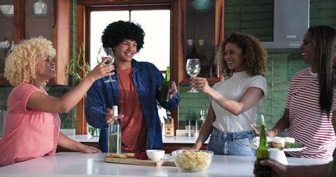 Friends Toasting with Wine in Modern Home Kitchen
