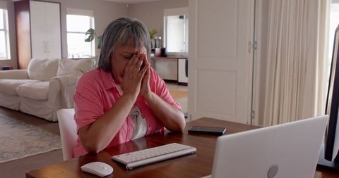 Frustrated senior woman using computer at home