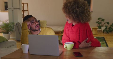 Biracial Couple Laughing Together at Home with Laptop