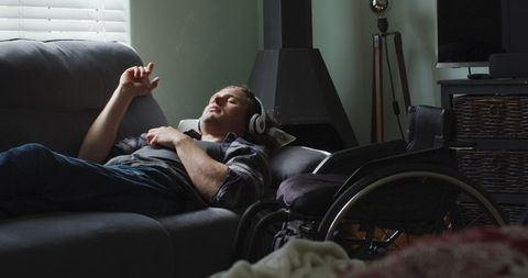 Relaxed Man with Headphones Relaxing in Living Room