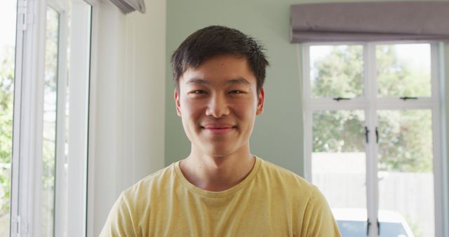 Portrait of happy asian man smiling in living room. spending quality time at home together.