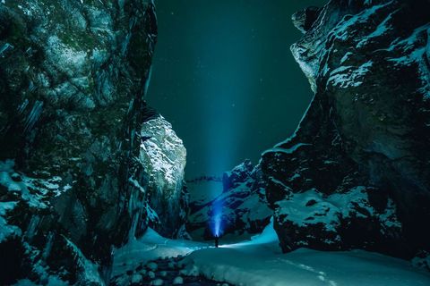 Night Hiker Shines Flashlight in Majestic Snowy Canyon