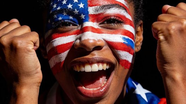 Black woman cheering with american flag face paint and raised fists, patriotic joy
