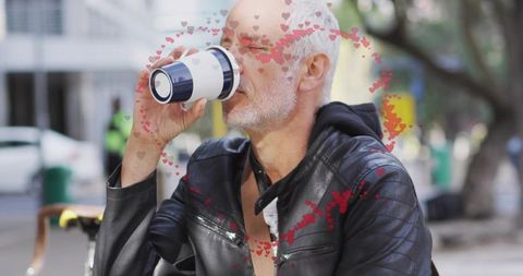 Senior man drinking from reusable travel mug on urban bench with heart overlay