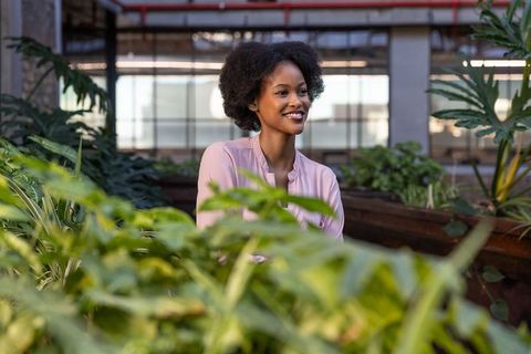 Professional woman in eco-friendly office atrium with indoor plants