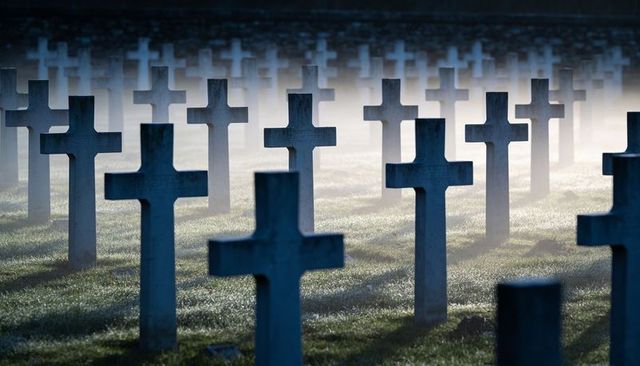 Dewy morning mist drifting through rows of stone latin crosses at memorial field