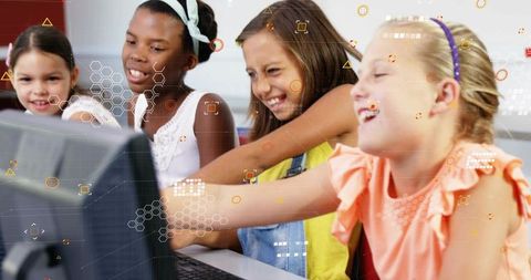 Elementary Girls Collaborating on Computer in Bright Classroom Learning Through Technology