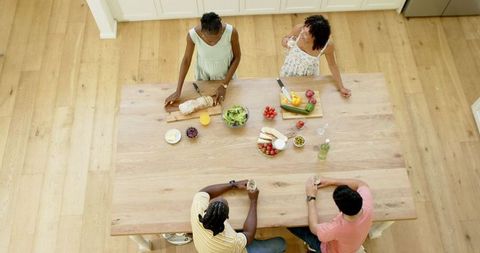 Friends Socializing While Preparing Healthy Meal in Kitchen