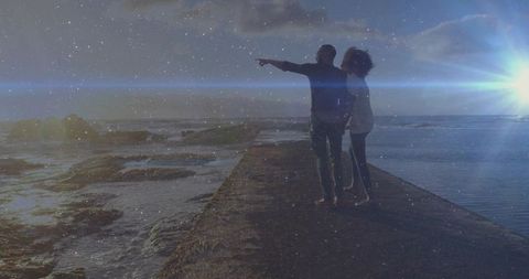 Silhouetted Couple Embracing Sunset on Ocean Pier
