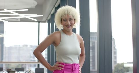 Confident Professional in Modern Office Setting Near Large Windows