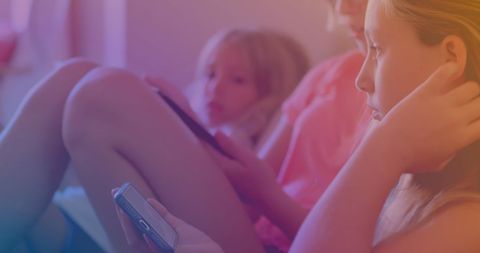 Caucasian Sisters Relaxing at Home Using Smartphones