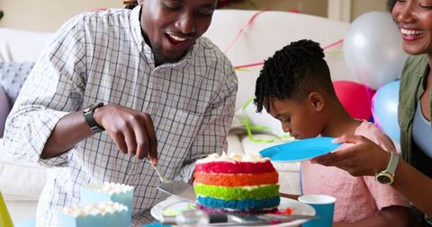 Diverse Family Celebrating Child's Birthday with Colorful Cake at Home