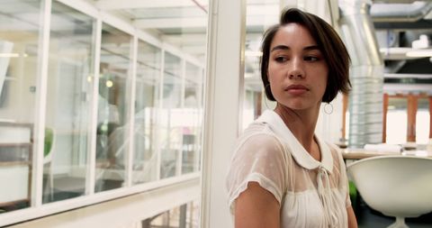 Thoughtful Businesswoman with Short Hair Looking Away in Modern Office