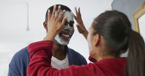 Joyful Couple Enjoying Skincare Routine Together at Home