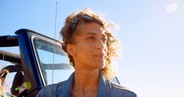 Young Woman with Curly Hair Enjoying a Sunny Day Outdoors - Download Free Stock Images Pikwizard.com