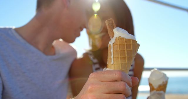 A young Caucasian couple enjoys ice cream cones on a sunny day, with copy space - Download Free Stock Photos Pikwizard.com