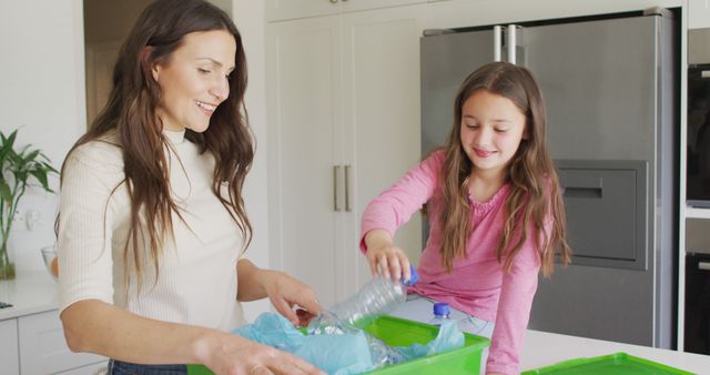Happy caucasian mother and daughter segregating rubbish in kitchen. family time, leisure and spending quality time at home.