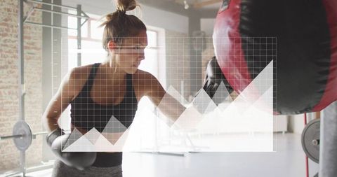 Woman boxing on heavy bag in industrial gym working out for strength and endurance