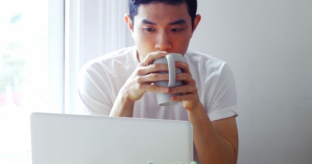 Man Drinking Coffee While Working on Laptop at Home - Download Free Stock Images Pikwizard.com