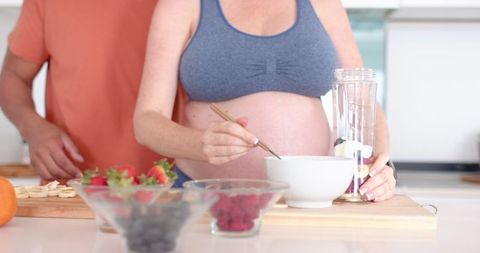 Diverse Female Couple Preparing Fresh Smoothie in Modern Kitchen