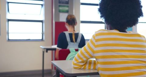 Students Attentively Listening in Classroom Near Windows