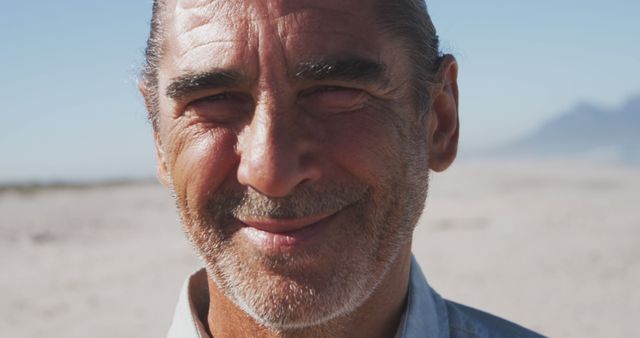 Portrait of happy senior caucasian man smiling on beach. Senior lifestyle, realxation, nature, free time and vacation.