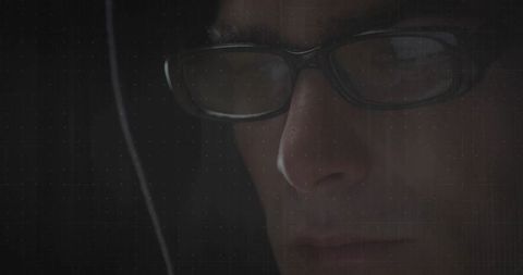 Mystery Man in Hood Analyzing in Dim Light illustrates Tech Focus