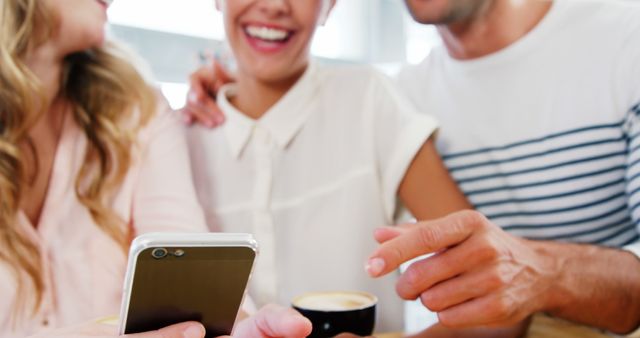 Friends Laughing Together While Looking at a Smartphone in a Cafe - Download Free Stock Images Pikwizard.com