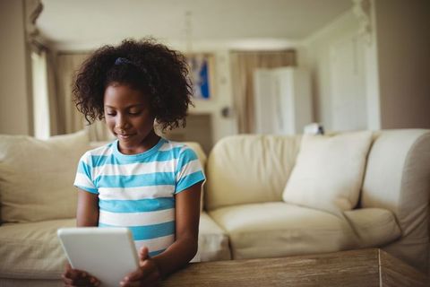 Young Girl Using Tablet in Cozy Living Room Environment - Download Free Stock Images Pikwizard.com