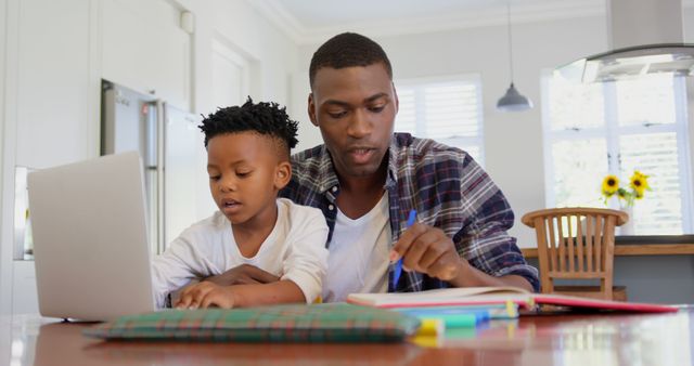 Father and Son Studying Together in Modern Kitchen - Download Free Stock Images Pikwizard.com