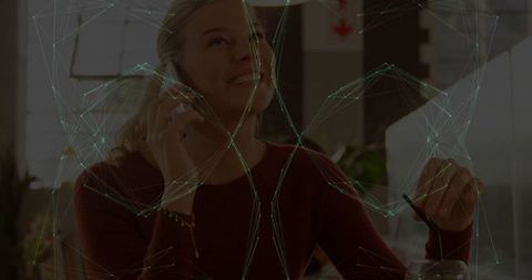 Woman Seated in Cafe Engaging with Smartphone and Drink