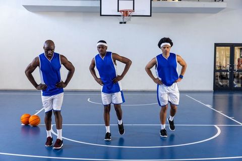 Diverse basketball team warming up on indoor court