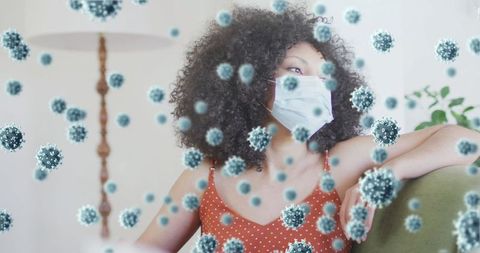 Masked woman amidst floating virus cells illustrating pandemic