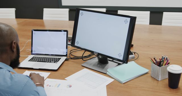 Businessman Working on Laptop and Desktop Monitors in Office Meeting Room - Download Free Stock Images Pikwizard.com