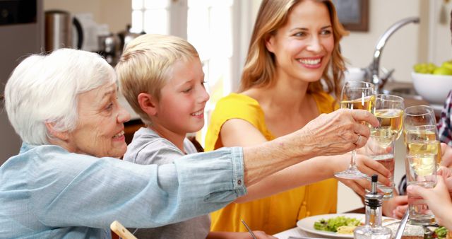 Multi-generational family enjoying meal and celebrating together around dining table. Great for content related to family gatherings, celebrations, holiday meals, and bonding moments.