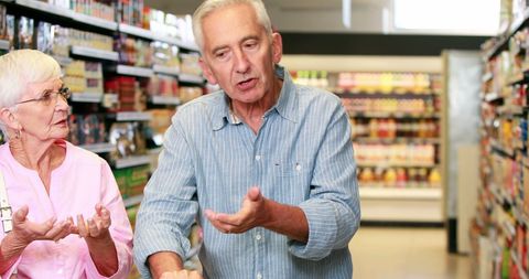 Senior Couple Grocery Shopping and Making Decisions