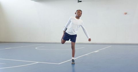 Young Athlete Stretching in Gym for Sports Training