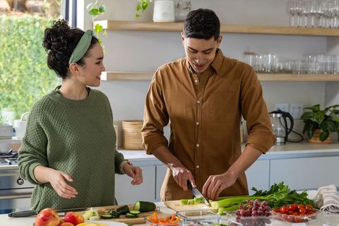 Young couple preparing healthy meal together in sunlit modern kitchen
