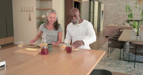 Senior couple sharing breakfast and berries at modern open-plan kitchen island