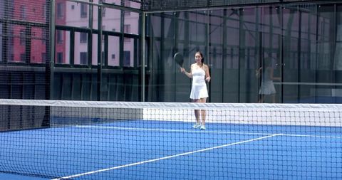 Woman Playing on Rooftop Padel Court with Glass Walls