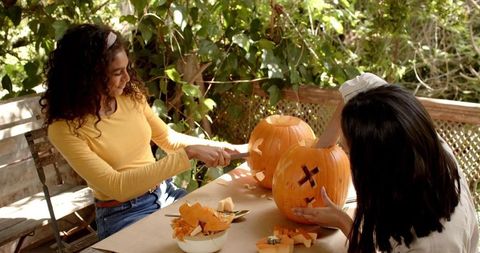 Friends carving pumpkins together